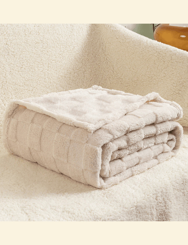 Beige Warmweave checkered blanket folded neatly on a soft cream sofa